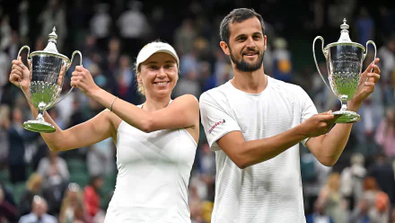 Lyudmyla Kichenok and Mate Pavic celebrate their victory at Wimbledon 2023, proudly holding their trophies amidst a lively crowd, capturing the essence of tennis excellence.