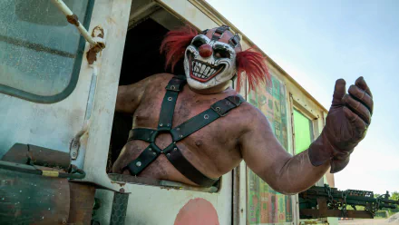 HD wallpaper featuring a Twisted Metal character resembling clown mask-wearing Joe Seanoa leaning out of a vehicle window