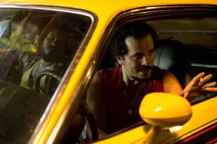 HD wallpaper featuring a man in conversation inside a yellow car for a desktop background.