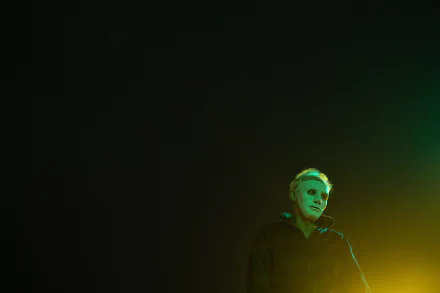 HD desktop wallpaper featuring a shadowy figure in a dark room with ominous green lighting, evoking a sense of mystery and suspense.