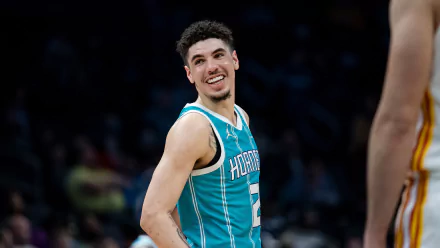 LaMelo Ball smiles during a game for the Charlotte Hornets, showcasing his vibrant personality and passion for basketball in this HD desktop wallpaper background.