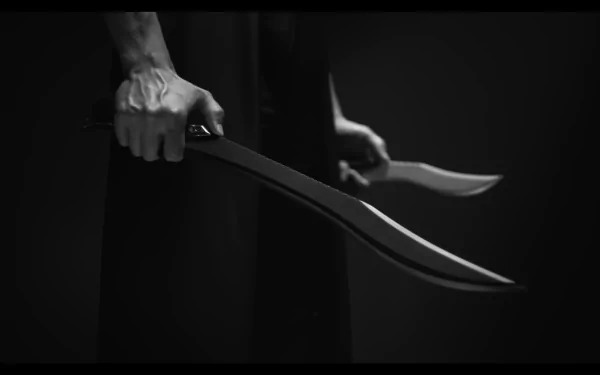 Black and white HD wallpaper featuring a close-up of a person's hand holding a curved blade, invoking Dune: Part Two's thematic elements.