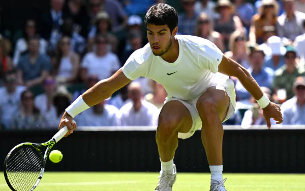 Carlos Alcaraz skillfully dives to reach a tennis ball during Wimbledon 2023, capturing the intensity and excitement of the sport in this HD wallpaper.
