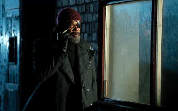 HD desktop wallpaper from the TV show Secret Invasion featuring the character Nick Fury, portrayed by Samuel L. Jackson, using a phone in a dimly lit environment.