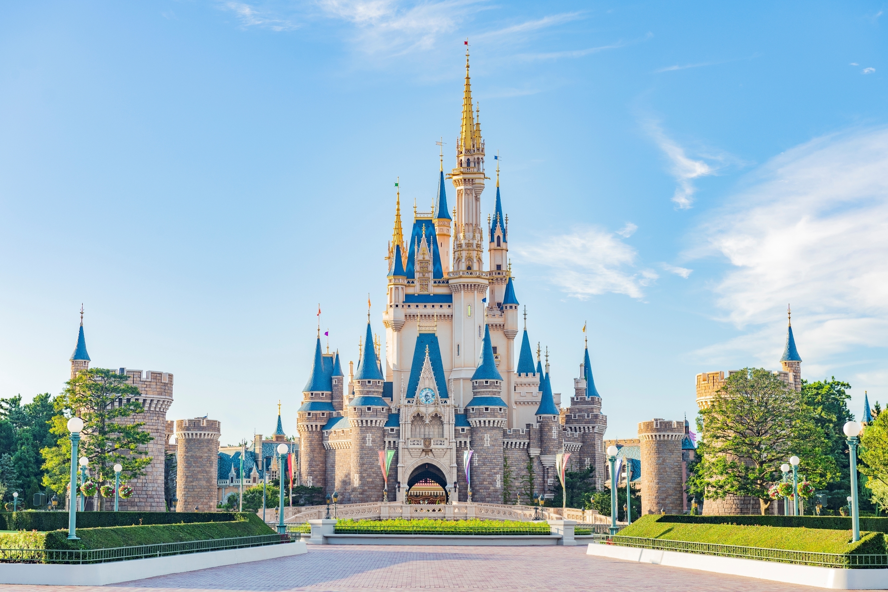 HD wallpaper of Cinderella Castle at Tokyo Disneyland with a clear blue sky backdrop.