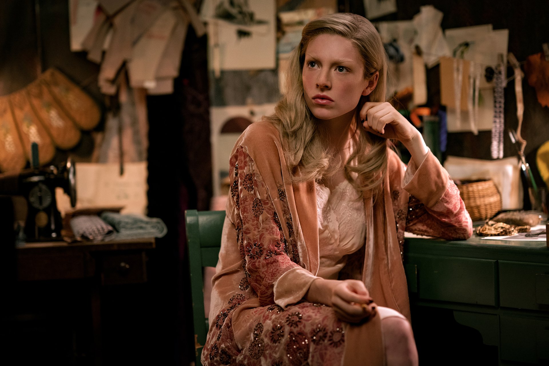 HD desktop wallpaper of a contemplative character from The Hunger Games: The Ballad of Songbirds & Snakes, set against a background filled with papers and vintage decor.