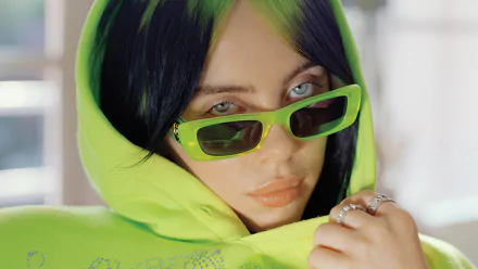 HD wallpaper featuring a person in a green hoodie and sunglasses, making it a vibrant desktop background.