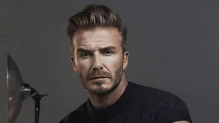 David Beckham poses confidently against a dark background in this HD desktop wallpaper, showcasing his iconic style and presence in the world of sports.