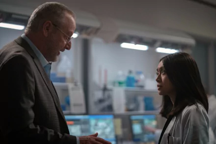 HD desktop wallpaper from For All Mankind featuring a man and woman in conversation in a dimly lit room.