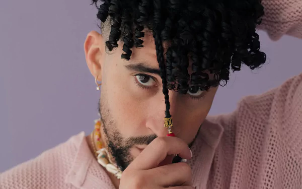 Stylish individual posing with a thoughtful expression for a high-definition desktop wallpaper with a soft purple background.