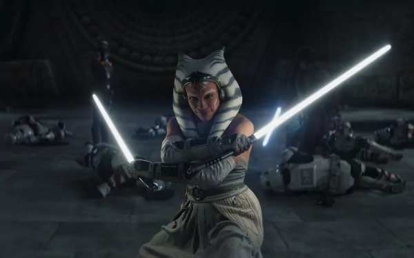 Ahsoka Tano, from the 2023 TV show Ahsoka, stands ready with twin lightsabers, surrounded by defeated opponents, in this striking HD desktop wallpaper.