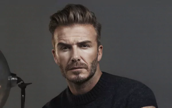 David Beckham poses confidently against a dark background in this HD desktop wallpaper, showcasing his iconic style and presence in the world of sports.