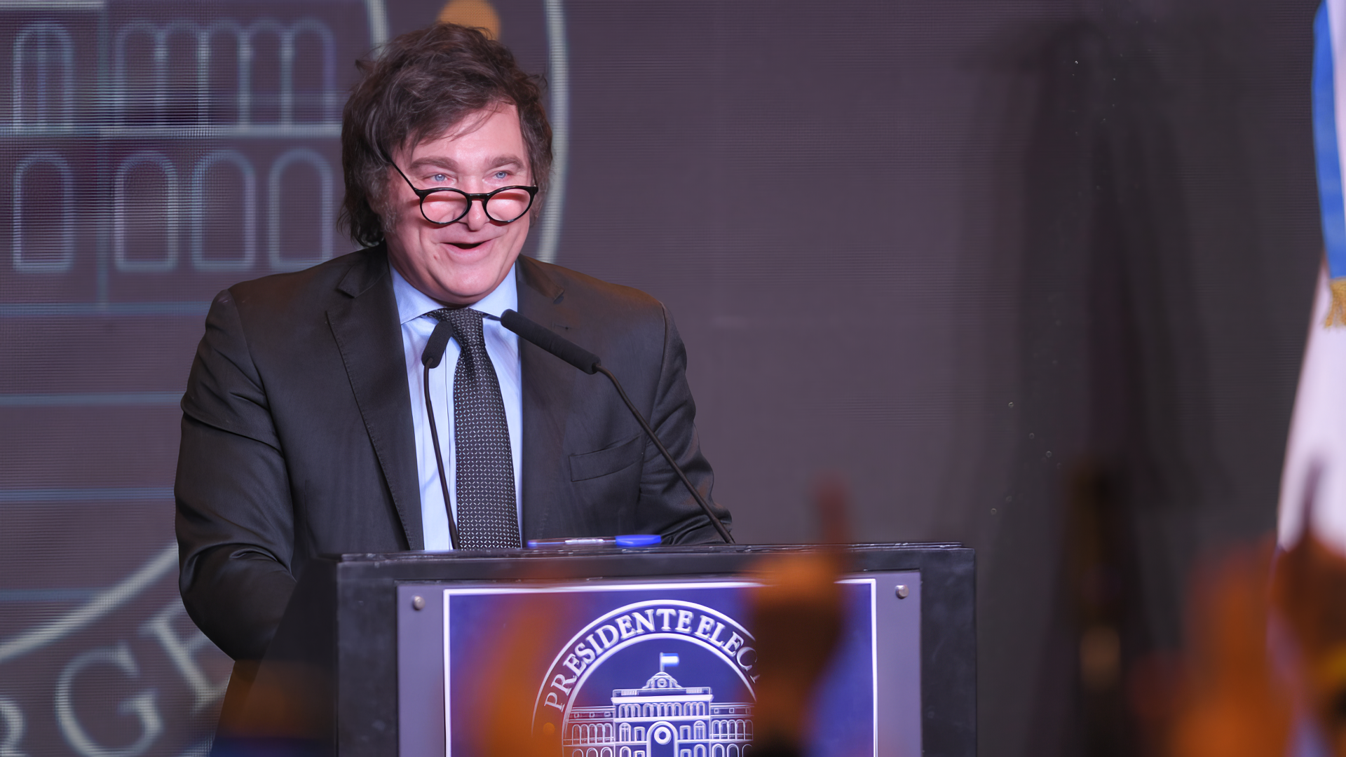 Man speaking at a podium with Presidente Electo sign, suitable as an HD desktop wallpaper or background.