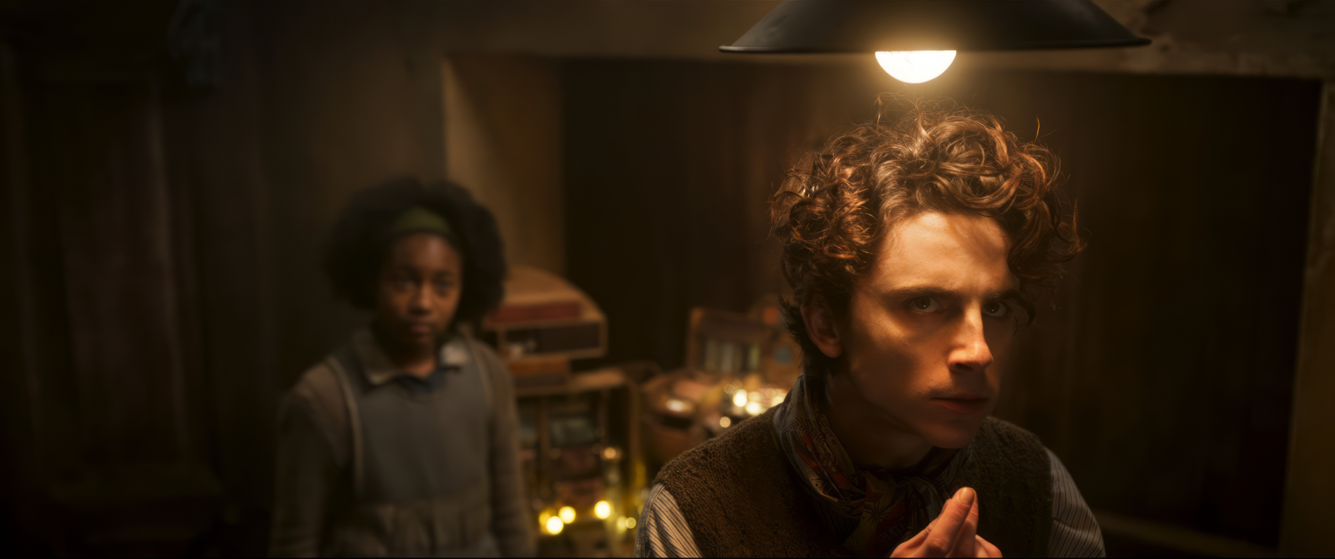 HD desktop wallpaper featuring a scene from the movie 'Wonka' with a thoughtful character in the foreground.