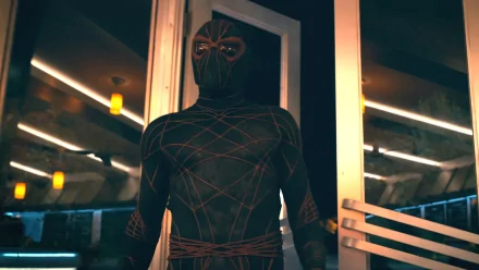 HD desktop wallpaper of Ezekiel Sims, linked to Madame Web, with actor Tahar Rahim in a spider-themed suit, standing in a neon-lit environment.