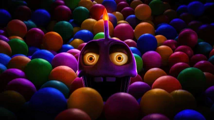 A vibrant HD wallpaper featuring a character from Five Nights at Freddy's, emerging from a sea of colorful balls, illuminated by a candle atop its head.