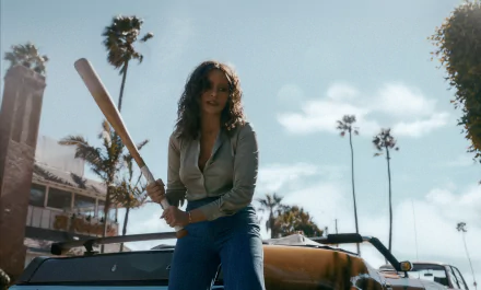 HD Wallpaper from Griselda TV Show 2024, featuring a woman holding a baseball bat with a classic car and palm trees in the background.