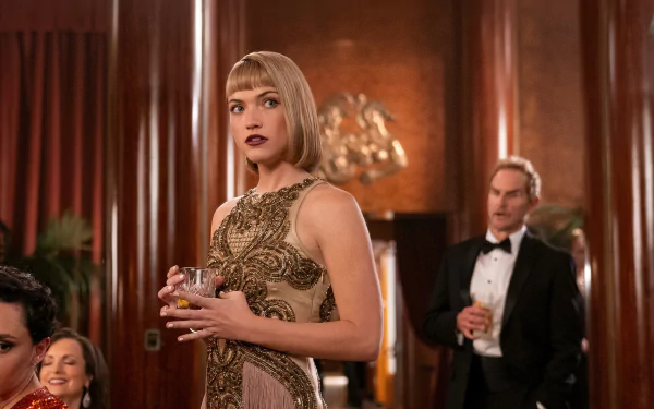 A stylish scene from the TV show Death and Other Details, featuring a woman in a glamorous dress, holding a drink, with a man in a tuxedo in the background, set in an elegant interior.