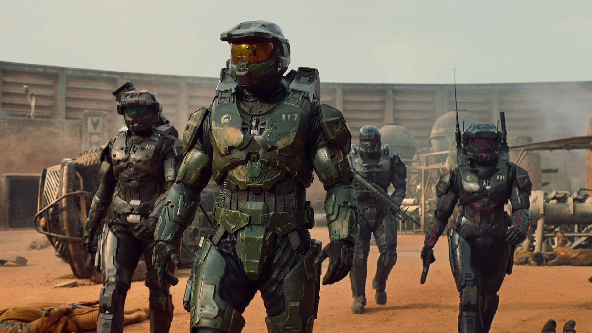 A high-definition desktop wallpaper featuring characters in combat armor from the TV show Halo, walking through a rugged, barren landscape.
