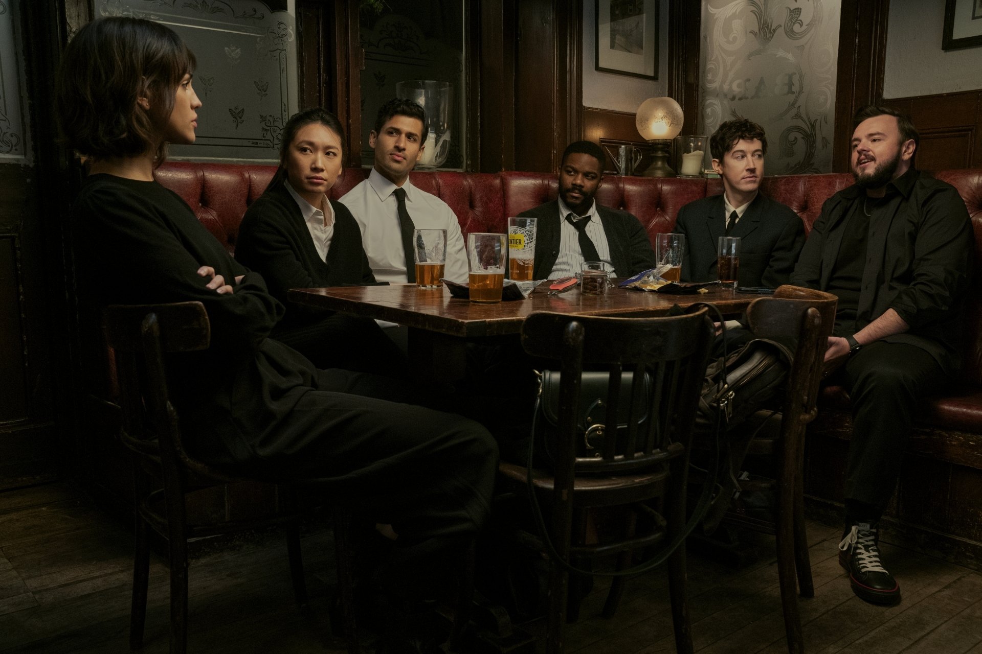 Cast members from the TV Show 3-Body Problem gathered in a dimly lit pub, featured in an HD desktop wallpaper.
