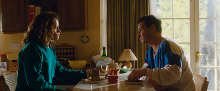 HD wallpaper featuring a scene from the movie 'All of Us Strangers' with two characters engaging in a conversation at a kitchen table.