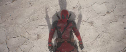 A high-definition desktop wallpaper featuring Deadpool lying on the ground, with a shadow of Wolverine’s claws prominently displayed behind him.