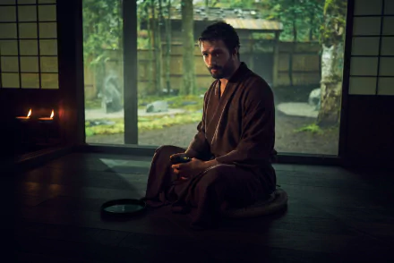 HD wallpaper of a brooding character from the 2024 TV show Shogun, seated contemplatively in a traditional Japanese room with serene garden view.