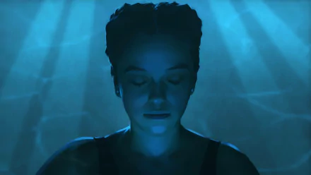 HD wallpaper featuring a serene character from the video game As Dusk Falls, bathed in a calming blue light.