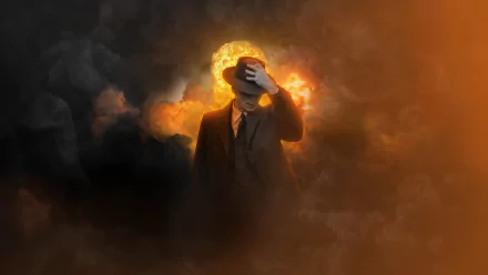 HD desktop wallpaper featuring a stylized image related to the movie Oppenheimer with a figure standing in front of an explosive backdrop, evoking themes from the movie.