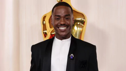 HD desktop wallpaper featuring Ncuti Gatwa at the Academy Awards, posing with an Oscars statue in the background.
