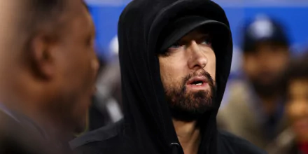 HD wallpaper of a person wearing a black hoodie, looking off to the side, with a focused expression.