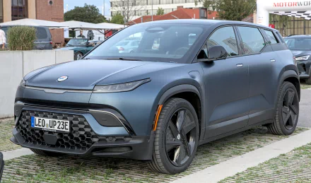 HD wallpaper of a matte gray Fisker Ocean electric SUV parked outdoors, showcasing its sleek design and eco-friendly appeal.