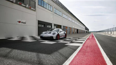 Porsche 911 GT3 RS parked on a race track pit lane with checkered pattern, suitable as HD wallpaper or background.