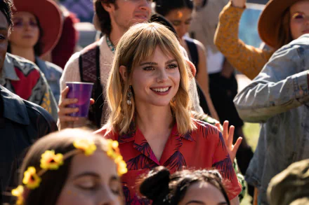 HD desktop wallpaper featuring Lucy Boynton from the movie The Greatest Hits, set in a lively outdoor scene.