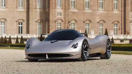 HD Wallpaper of a sleek silver Pagani Alisea supercar parked in front of a classic building with intricate architecture.