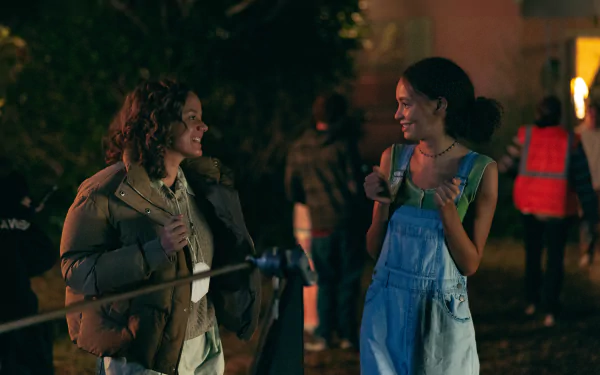HD wallpaper from the 2024 movie Suncoast featuring two characters smiling and chatting at night.