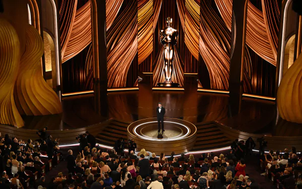 HD desktop wallpaper featuring an elegant scene from the Academy Awards (Oscars) with audience and a speaker on stage.