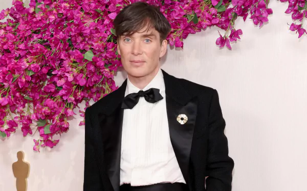 HD wallpaper featuring a person at the Academy Awards event, dressed in formal attire with a flower-filled backdrop.