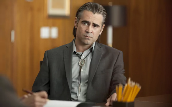 HD wallpaper of a True Detective TV show character sitting thoughtfully at a desk with a badge, evoking the intense atmosphere of the series.