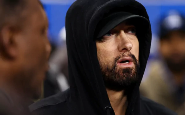 HD wallpaper of a person wearing a black hoodie, looking off to the side, with a focused expression.