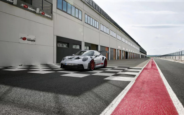 Porsche 911 GT3 RS parked on a race track pit lane with checkered pattern, suitable as HD wallpaper or background.