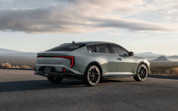 Kia K4 GT-Line car displayed as an HD desktop wallpaper with a scenic desert backdrop.