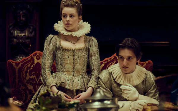 HD wallpaper of Mary & George from TV show, featuring two characters in period costumes sitting at a lavish dining table.