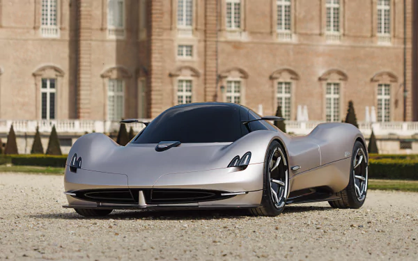 HD Wallpaper of a sleek silver Pagani Alisea supercar parked in front of a classic building with intricate architecture.