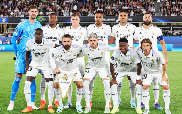 HD wallpaper featuring Real Madrid C.F. soccer team posing together in their white home kits before a match.