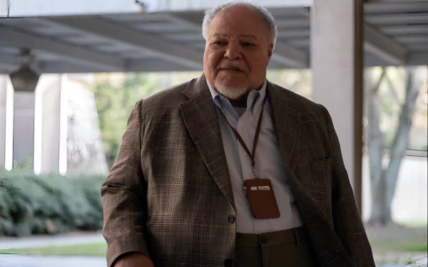 HD desktop wallpaper featuring a character from the movie Civil War (2024), standing in a covered outdoor area, dressed in a blazer and showing an ID badge.