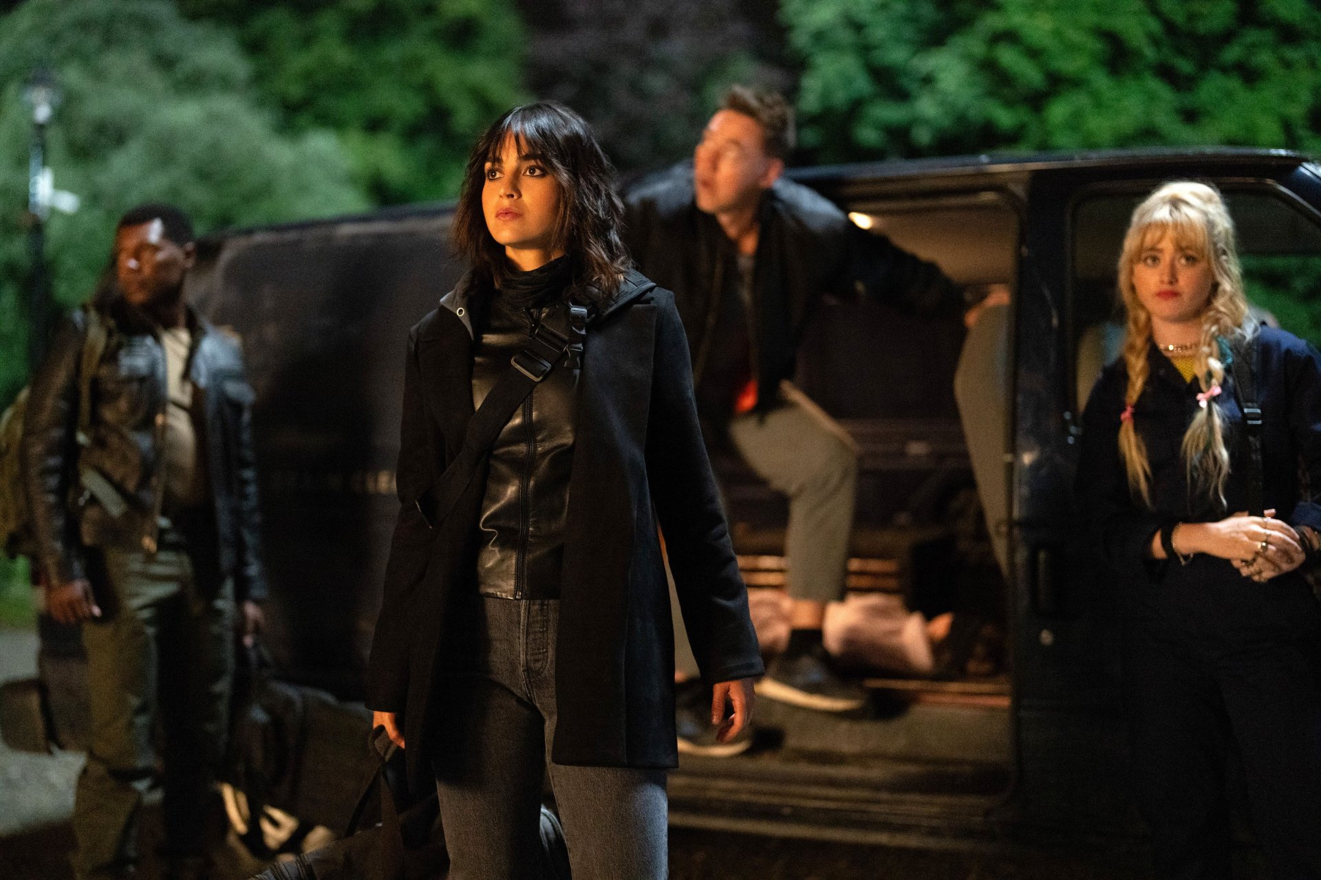 HD desktop wallpaper from the movie Abigail (2024) featuring a tense scene with four characters standing beside a vehicle at night.