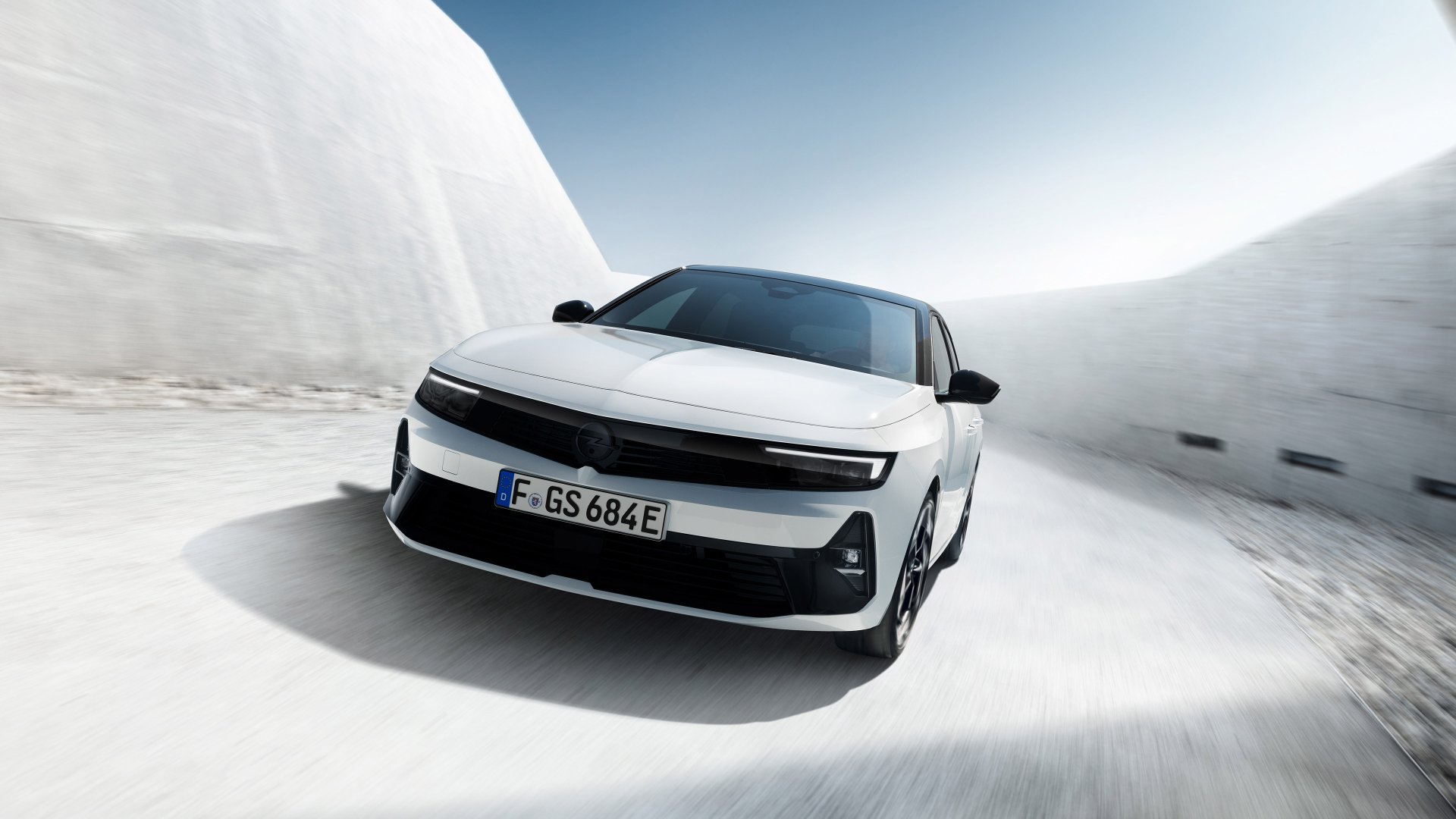 A sleek white Opel Astra GSe drives through a snowy landscape, captured in high definition for a stunning desktop wallpaper and background.