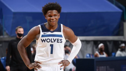 Minnesota Timberwolves player Anthony Edwards, smiling and wearing jersey number 1, on a basketball court. High-definition desktop wallpaper.