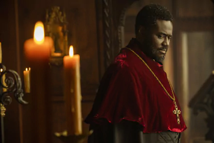 A captivating HD desktop wallpaper from the TV show Shardlake, featuring a character in a red robe with a cross, illuminated by candlelight in a dramatic, historical setting.